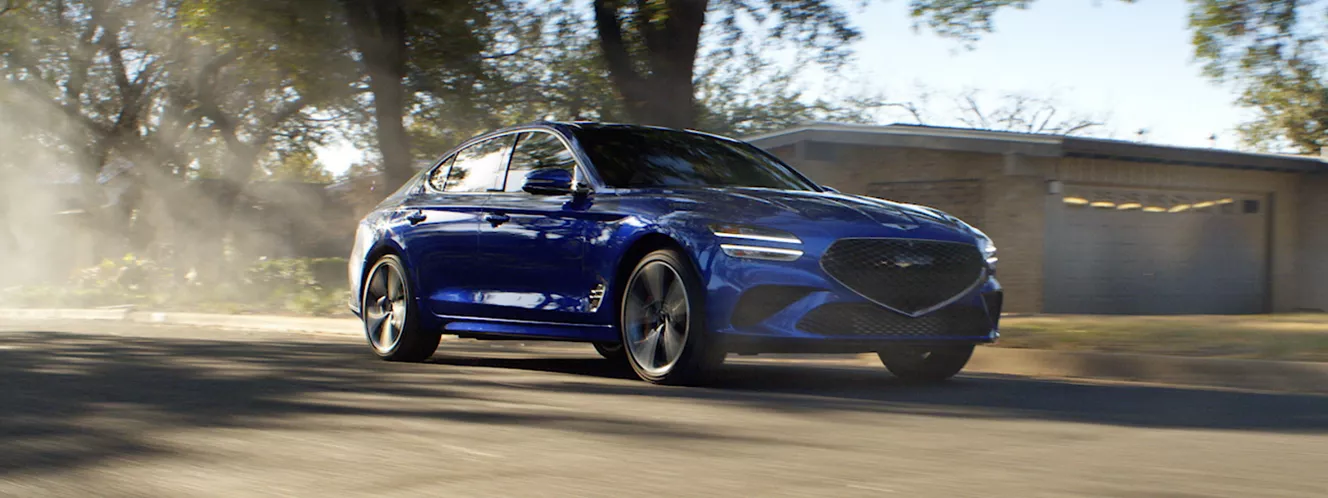 blue 2025 genesis g70 driving, left side view of vehicle
